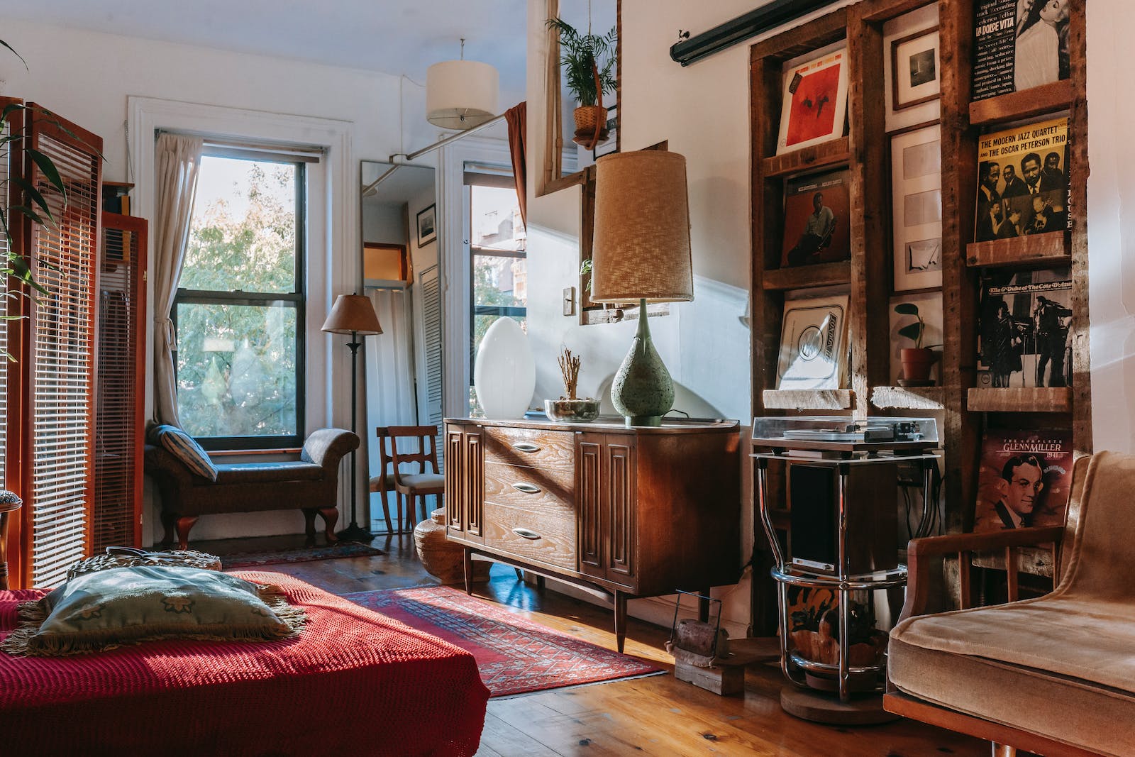 Interior of cozy studio with bed and couch decorated with vintage furniture and vinyl records