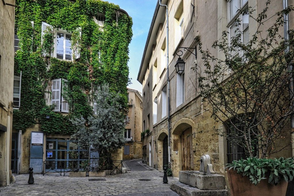Charming cobblestone street in European town lined with ivy-clad buildings and rustic street lamps